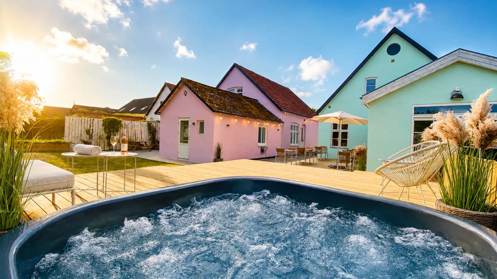 Der Hot Tub im Garten, dahinter das rosa und das grüne Haus
