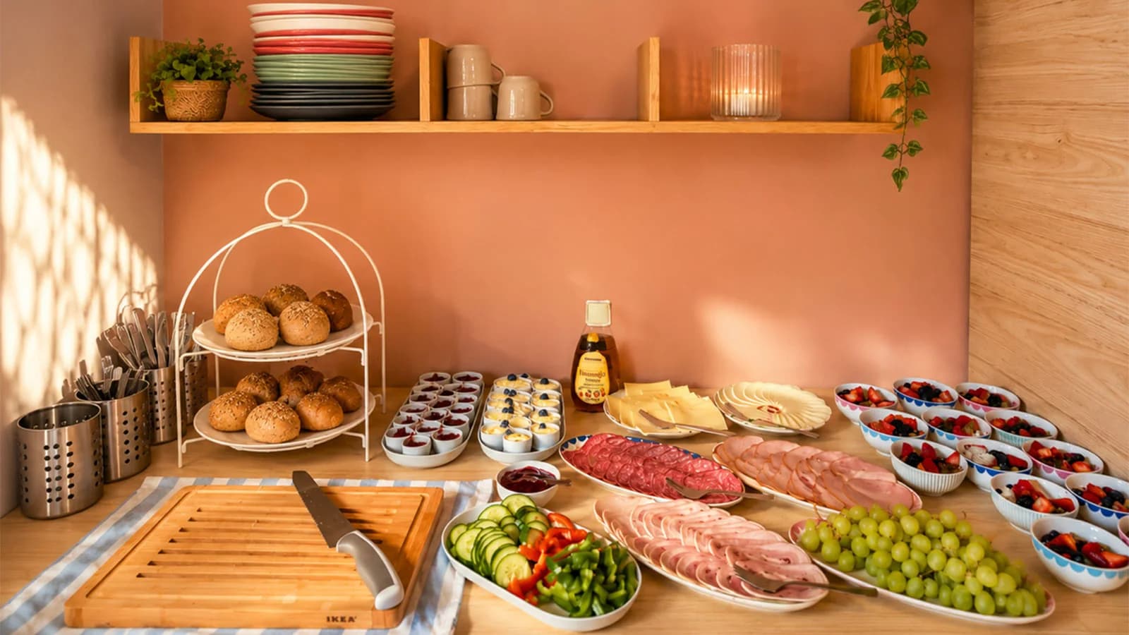 Frühstückstisch mit Brot, Aufschnitt und frischem Obst