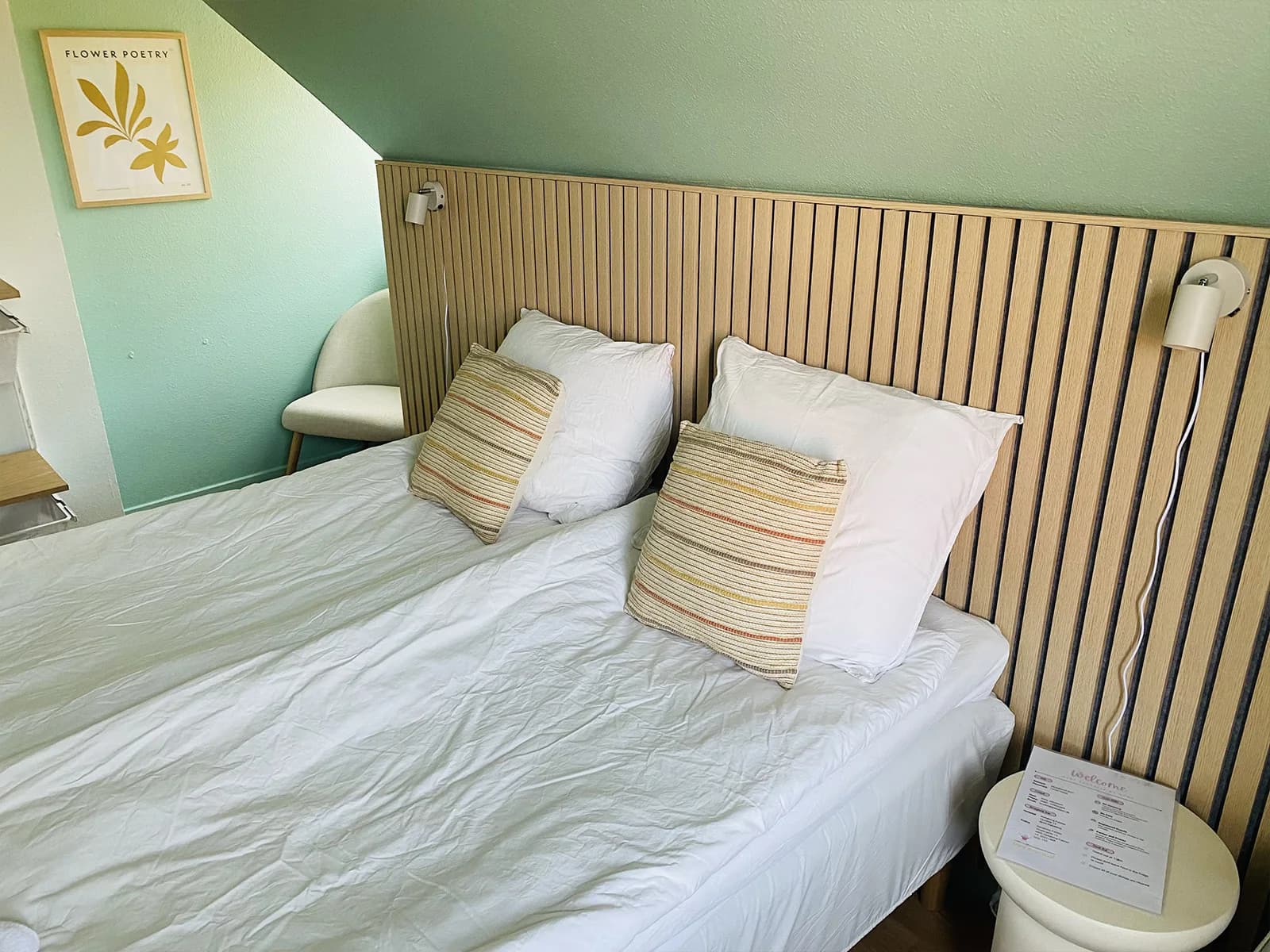 Doppelzimmer mit eigenem WC und Holzpaneel hinter dem Bett